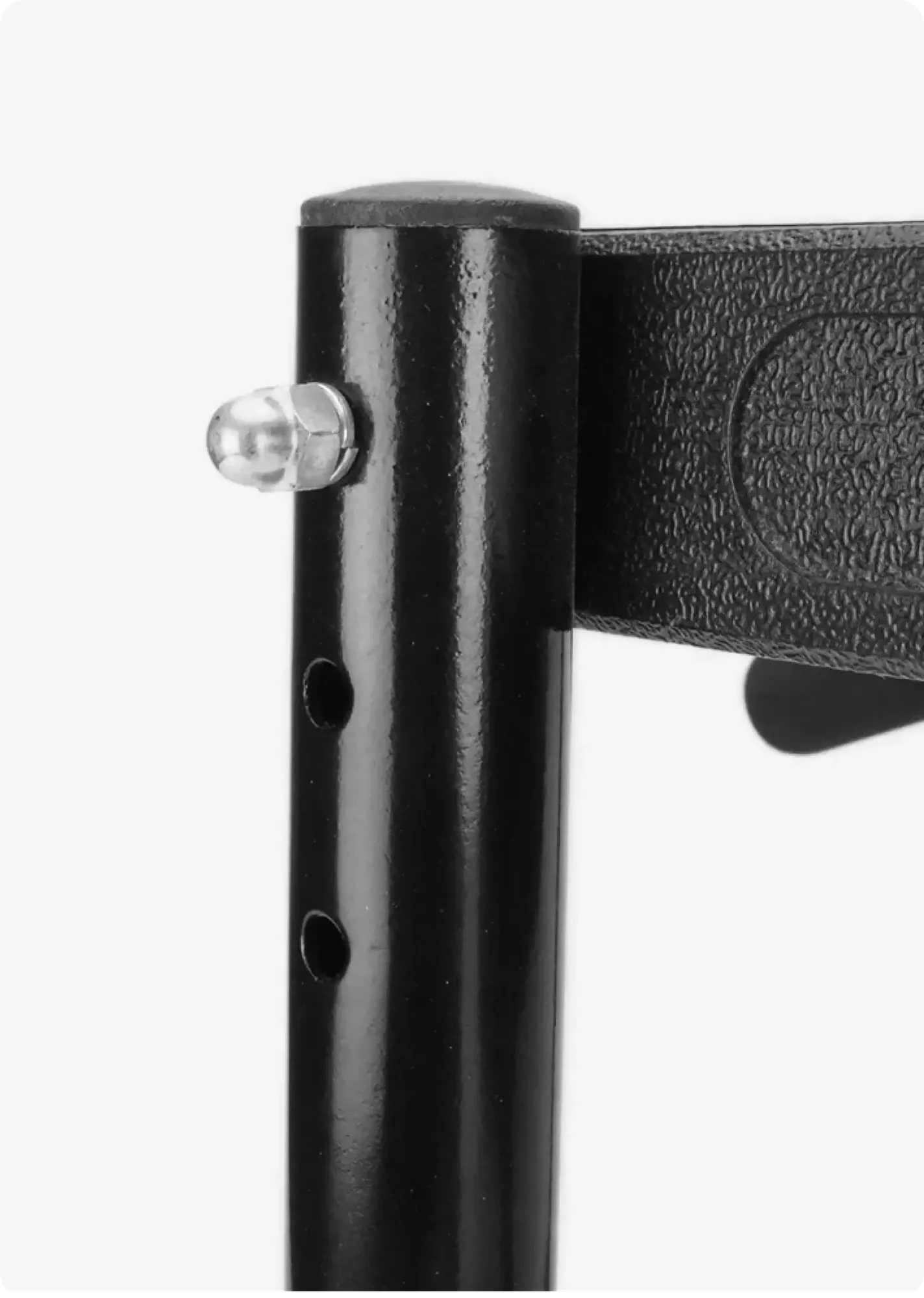 Close-up of the pull-up bar's adjustable bracket: a steel upright with a spring-loaded locking pin and three height-adjustment holes