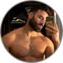 Joshua E., a bearded man flexing his arm in a gym mirror selfie
