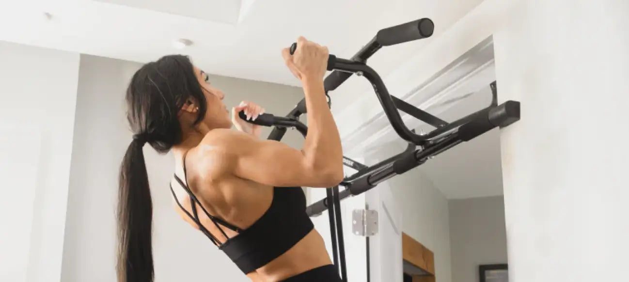 Woman doing a chin-up on the DMoose doorway pull-up bar mounted in a home doorway